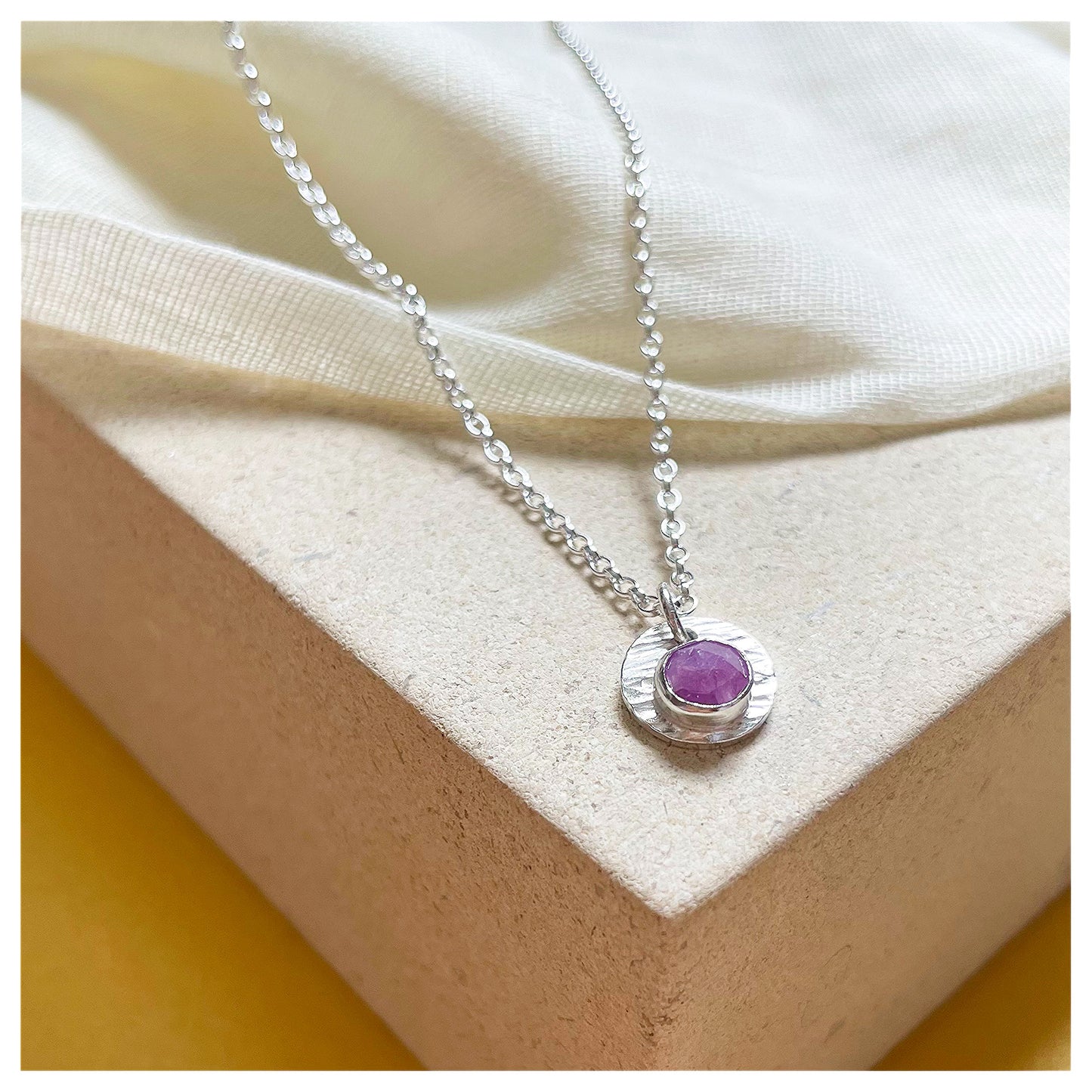 Sterling Silver and Ruby Hammered Disc Pendant.