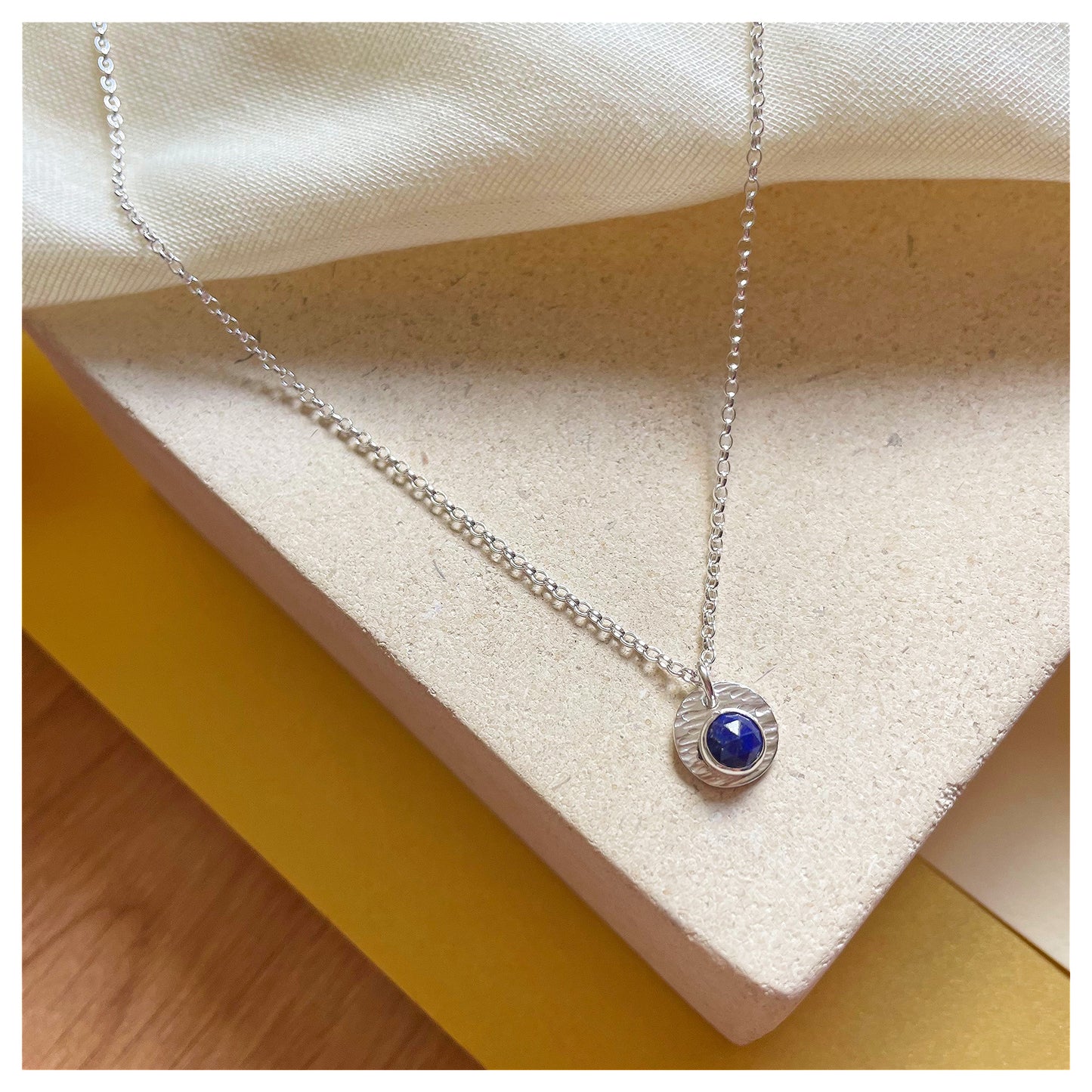 Sterling Silver and Lapis Lazuli Hammered Disc Pendant.