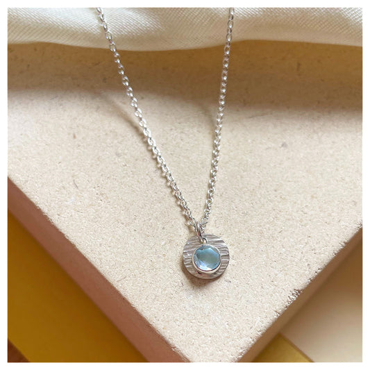 Sterling Silver and Blue Topaz Hammered Disc Pendant.