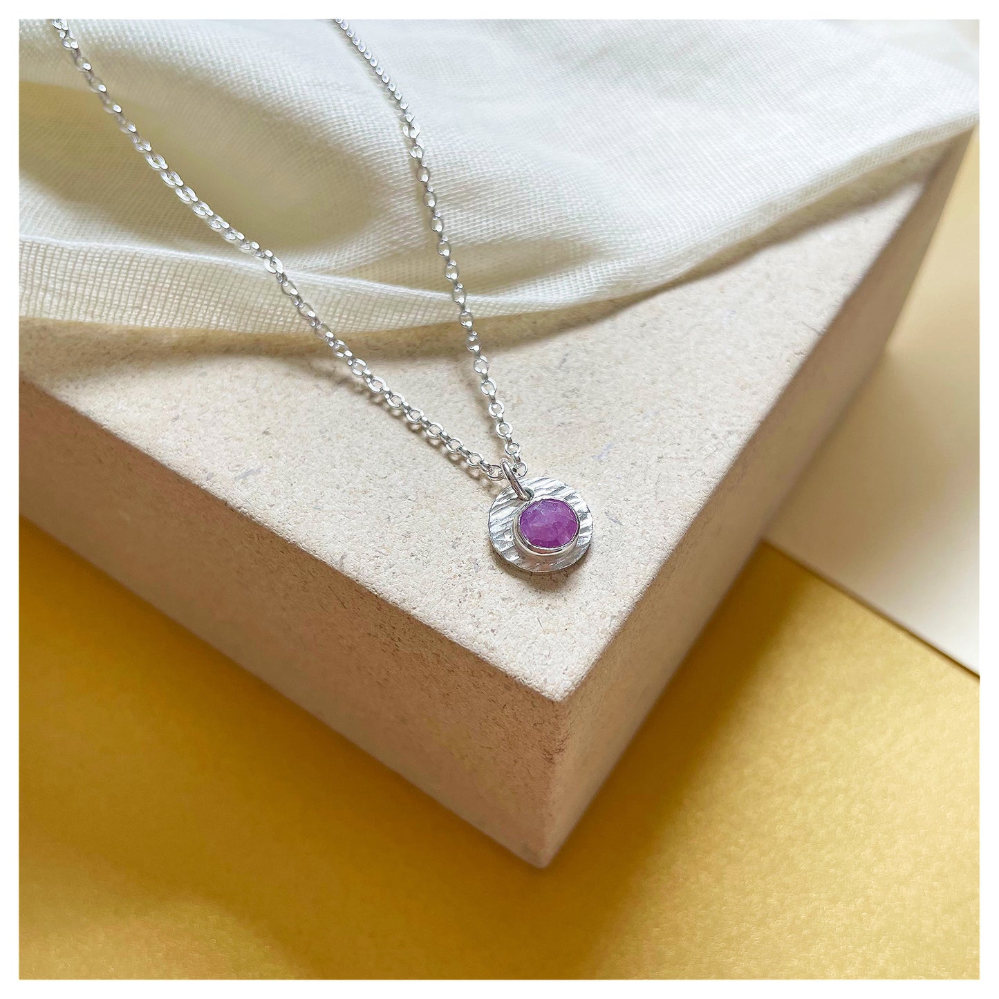 Sterling Silver and Ruby Hammered Disc Pendant.