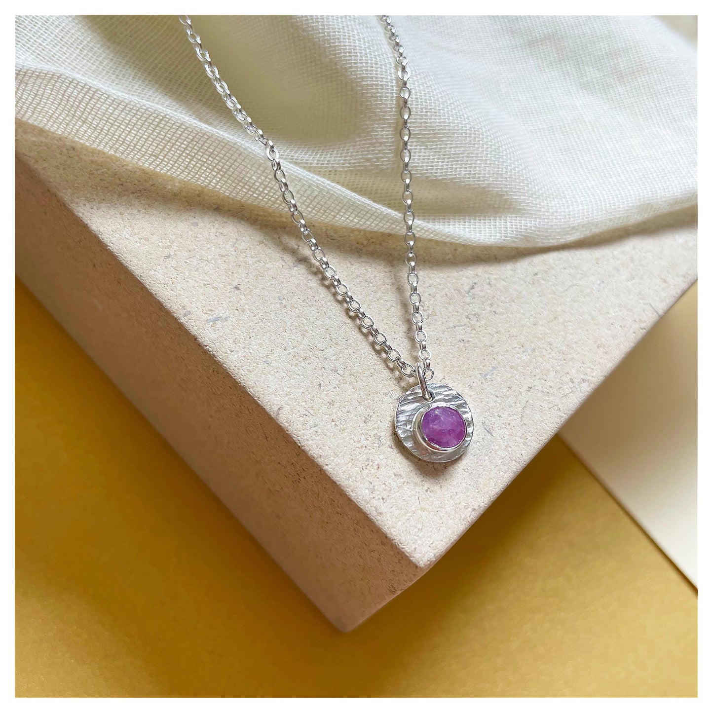 Sterling Silver and Ruby Hammered Disc Pendant.