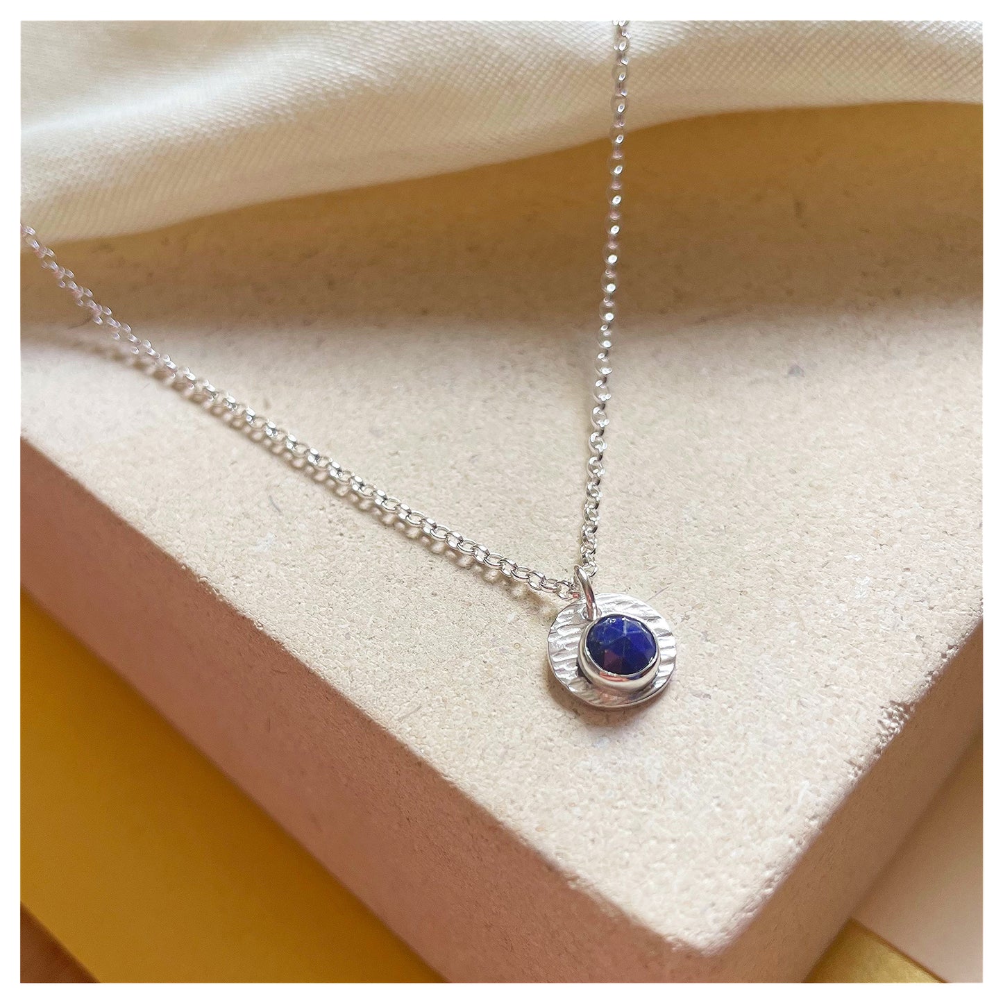 Sterling Silver and Lapis Lazuli Hammered Disc Pendant.