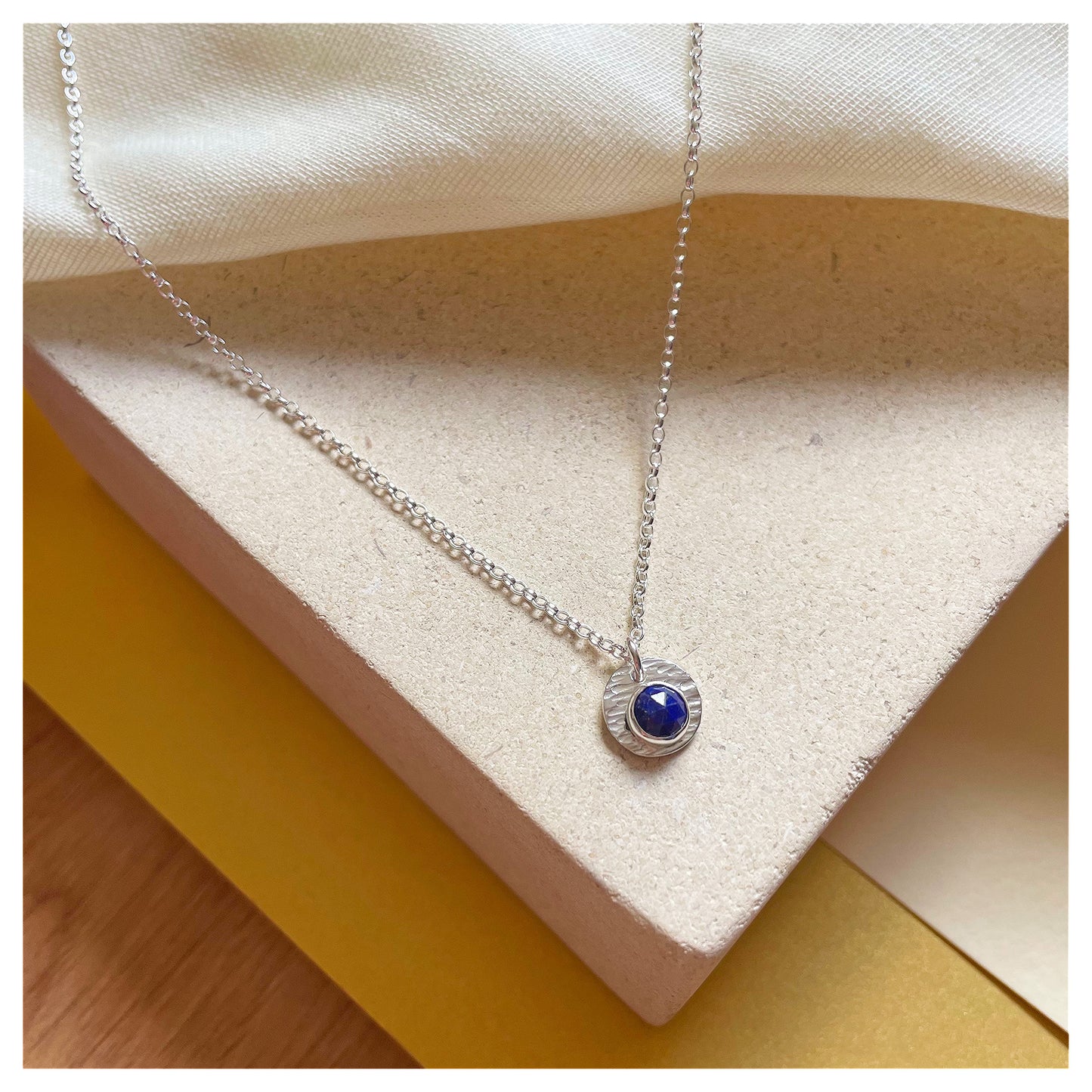 Sterling Silver and Lapis Lazuli Hammered Disc Pendant.