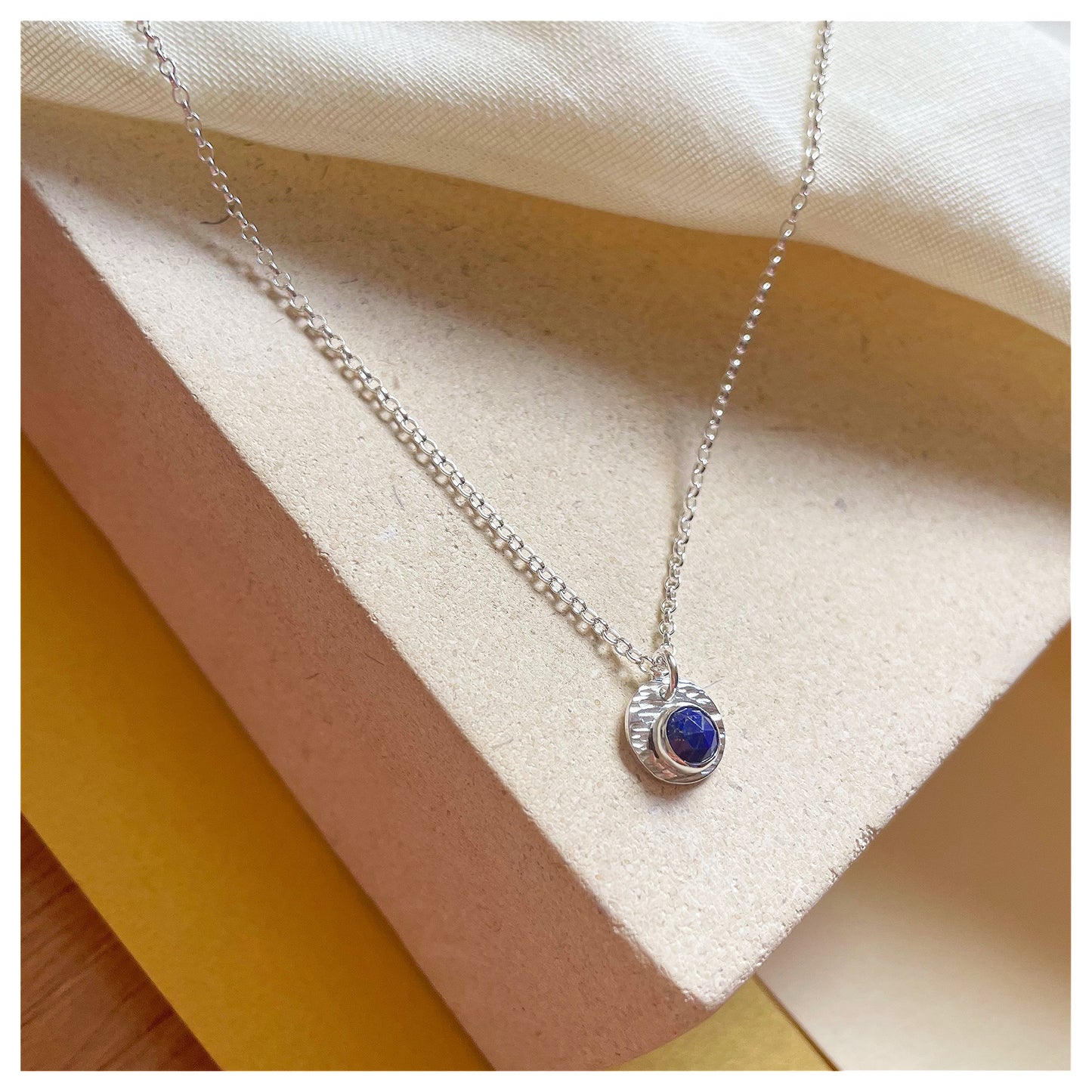 Sterling Silver and Lapis Lazuli Hammered Disc Pendant.